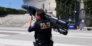 A New Orleans police officer shoulders a drone capture "gun"