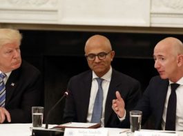 FILE - In this June 19, 2017, file photo President Donald Trump, left, and Satya Nadella, Chief Executive Officer of Microsoft, center, listen as Jeff Bezos, Chief Executive Officer of Amazon, speaks during an American Technology Council roundtable in the State Dinning Room of the White House in Washington. Amazon and Microsoft are battling for a $10 billion opportunity to build the U.S. military its first â€œwar cloud.â€ (AP Photo/Alex Brandon, File)