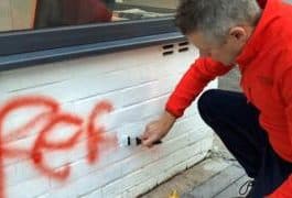 Luke Pollard painting over graffiti outside his office