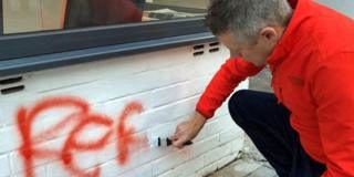 Luke Pollard painting over graffiti outside his office